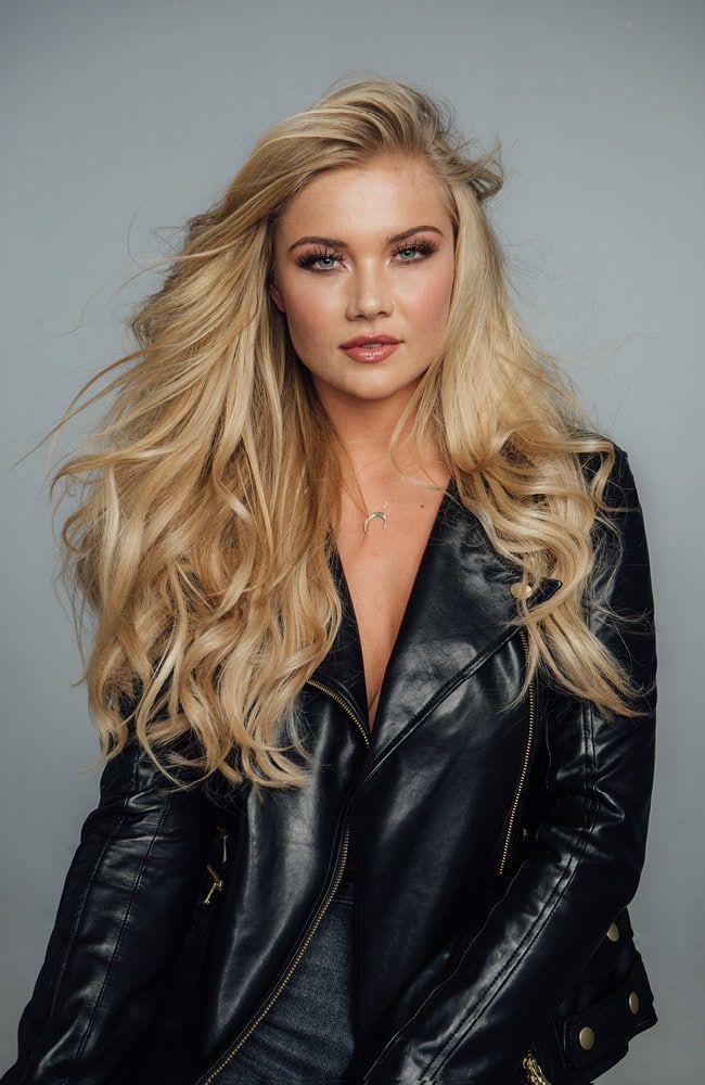 Frau mit langen blonden Haaren in einer LEderjacke